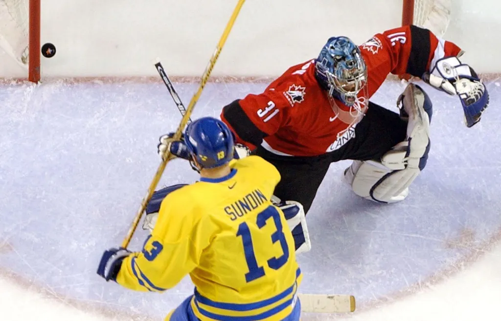 Mats Sundin sätter pucken bakom sin lagkamrat från Toronto Maple Leafs, Kanadas målvakt Curtis Joseph i OS-premiären som Tre Kronor vann med 5–2