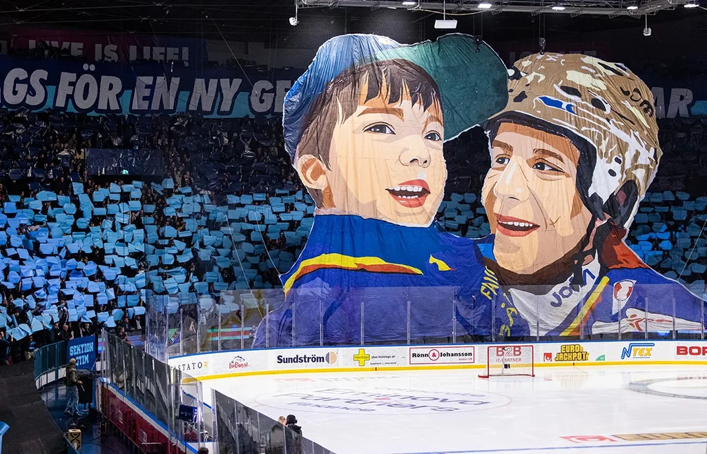 DIF-fansen med ett tifo som avbildar en ung Emil Berglund med pappa "Challe"